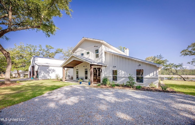 modern inspired farmhouse with board and batten siding, a chimney, and a front lawn
