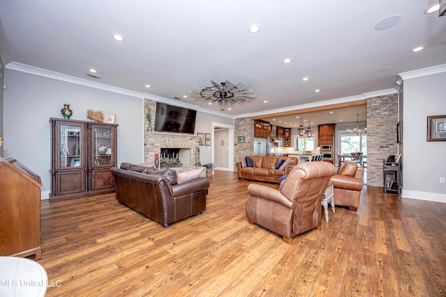 living area featuring crown molding, recessed lighting, hardwood / wood-style flooring, and a notable chandelier