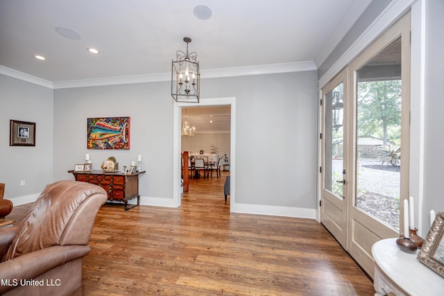 foyer featuring ornamental molding, light wood-style flooring, and a chandelier