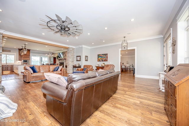 living room with recessed lighting, light wood-style flooring, a fireplace, and decorative columns