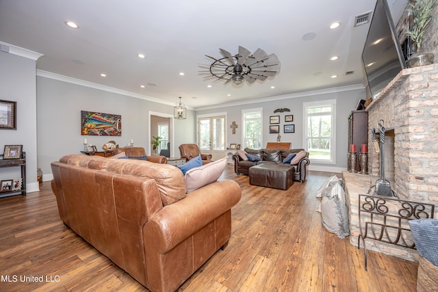 living area with recessed lighting, visible vents, ornamental molding, and hardwood / wood-style flooring