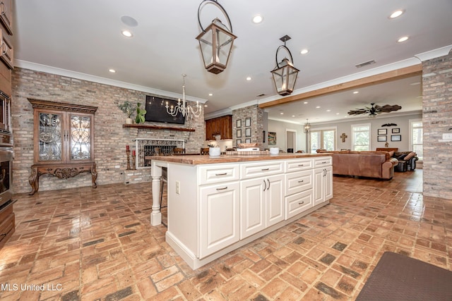 kitchen featuring recessed lighting, open floor plan, a brick fireplace, and brick floor