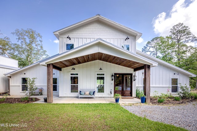 modern inspired farmhouse featuring brick siding, board and batten siding, and a front yard