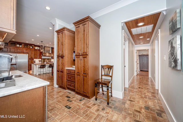corridor with a sink, brick floor, recessed lighting, baseboards, and visible vents