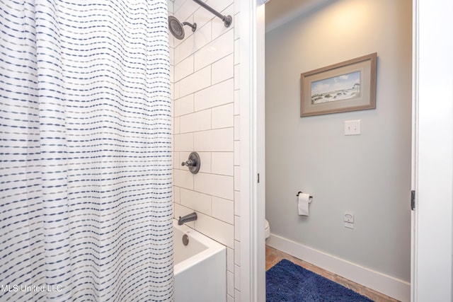 full bath featuring baseboards, shower / tub combo with curtain, tile patterned flooring, and toilet