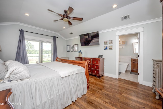 bedroom with vaulted ceiling, ornamental molding, wood finished floors, and visible vents