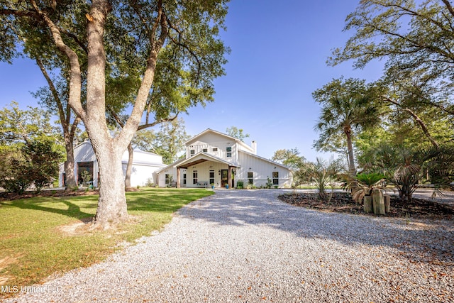 view of front of home with a chimney, driveway, and a front yard