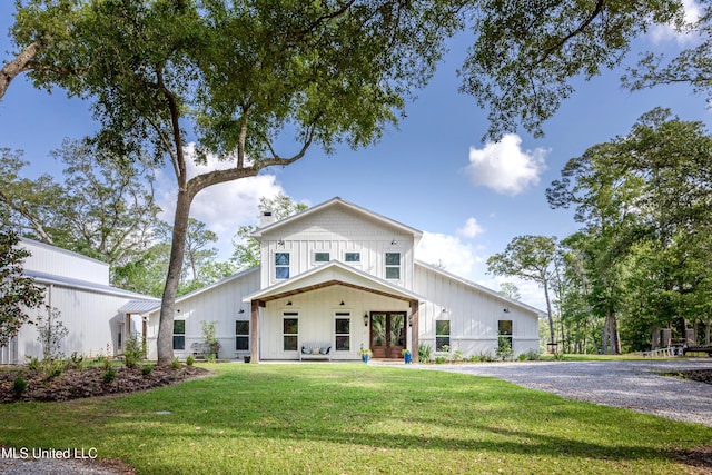 modern inspired farmhouse featuring a front lawn, board and batten siding, and fence