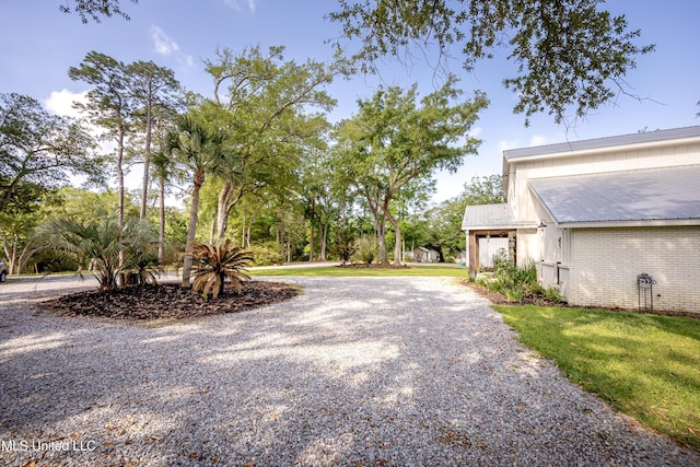 view of yard featuring a garage and gravel driveway