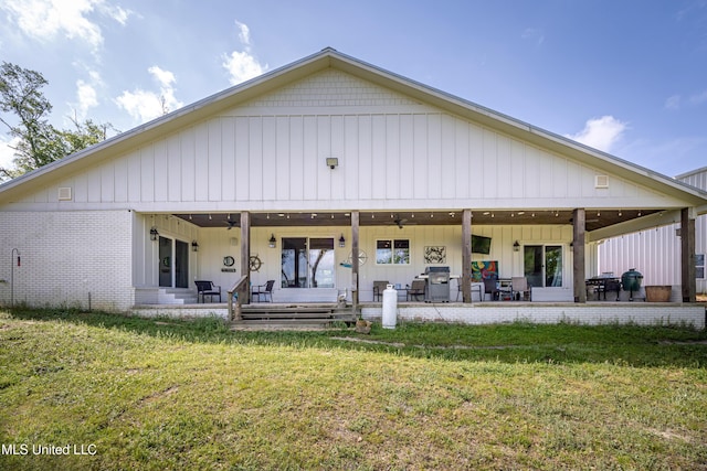rear view of property featuring a patio, ceiling fan, and a yard