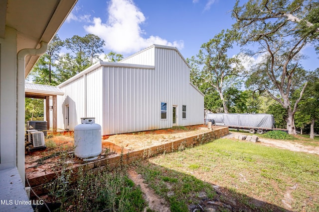 view of side of home featuring central air condition unit and a yard