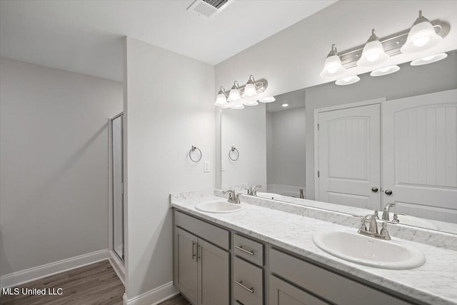 bathroom with vanity, an enclosed shower, and hardwood / wood-style flooring