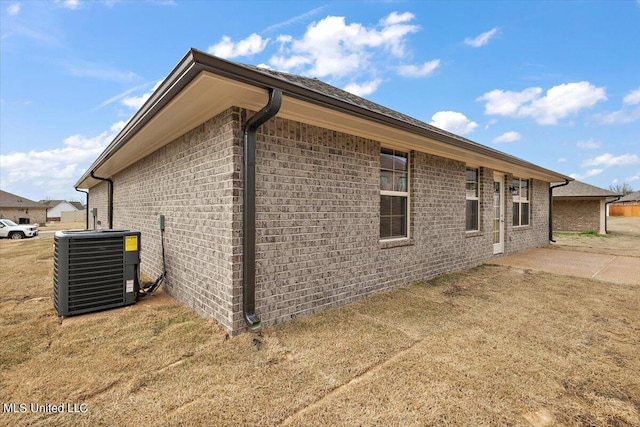 view of side of property with a patio area, central AC, and a yard