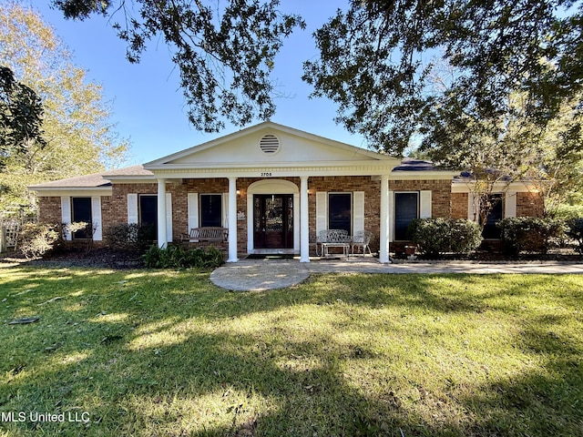 view of front of property with covered porch and a front lawn