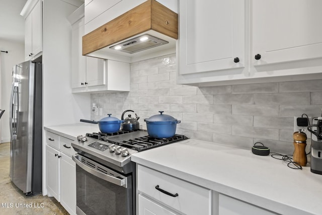 kitchen with stainless steel appliances, backsplash, light countertops, and white cabinets