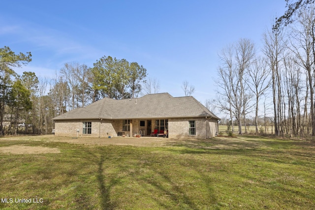 rear view of house with a yard and brick siding