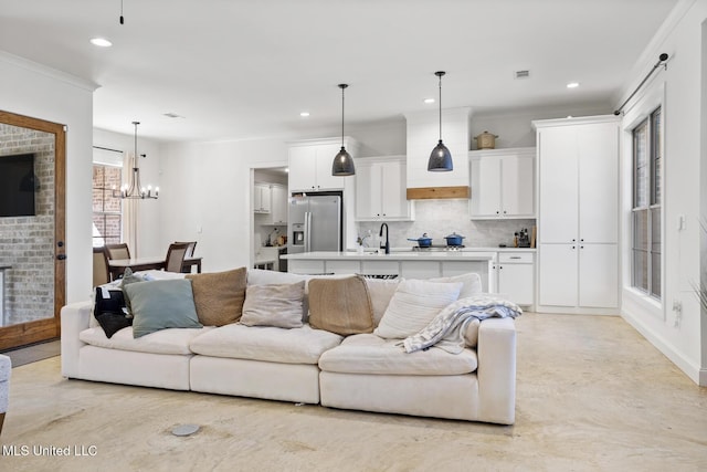 living area featuring ornamental molding, a notable chandelier, and recessed lighting