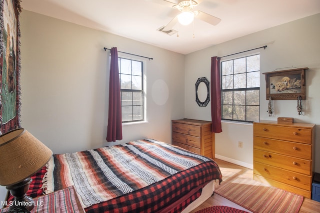 bedroom featuring light hardwood / wood-style floors, multiple windows, and ceiling fan