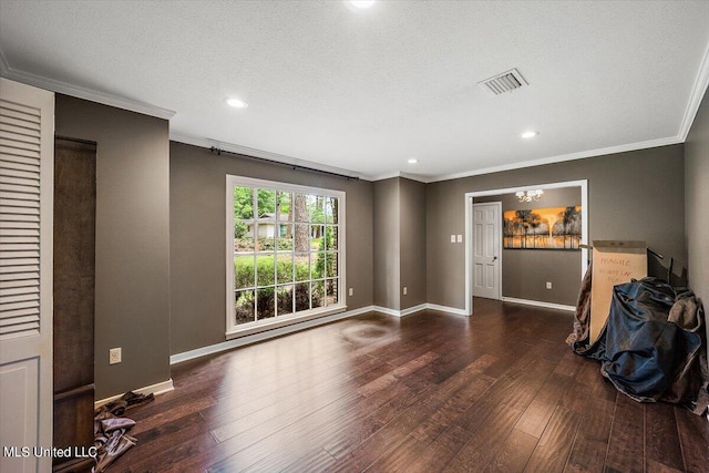 interior space featuring dark wood-type flooring, a textured ceiling, an inviting chandelier, and ornamental molding