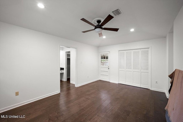 unfurnished bedroom with dark hardwood / wood-style floors, a closet, and ceiling fan