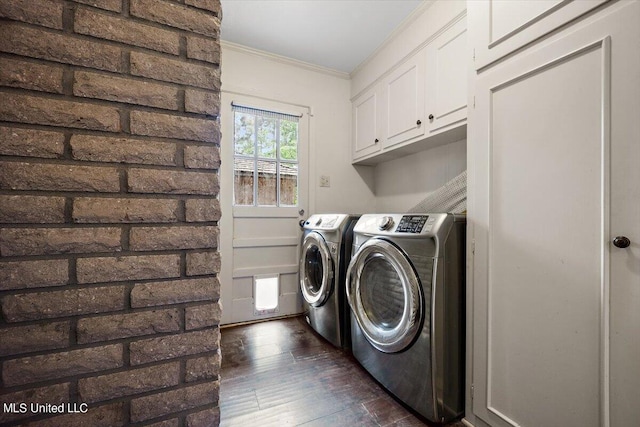 clothes washing area with cabinets, ornamental molding, washing machine and dryer, and dark hardwood / wood-style flooring