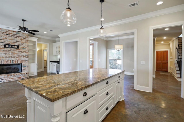 kitchen with a center island, pendant lighting, white cabinets, and built in shelves