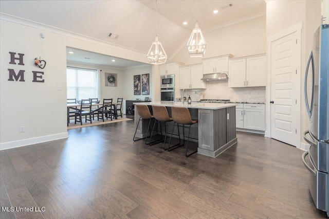 13604 Live Oak Loop, Olive Branch, MS 38654 - kitchen featuring stainless steel appliances, crown molding, under cabinet range hood, a chandelier, and white cabinets