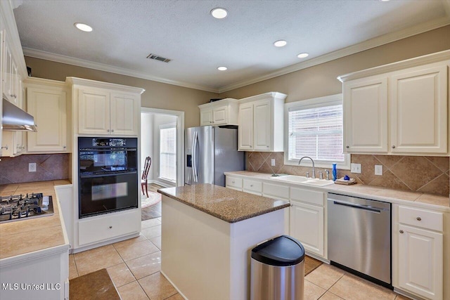 kitchen with a center island, sink, decorative backsplash, ornamental molding, and stainless steel appliances