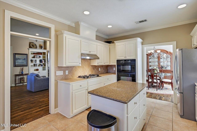 kitchen with ventilation hood, light wood-type flooring, stainless steel appliances, and white cabinetry