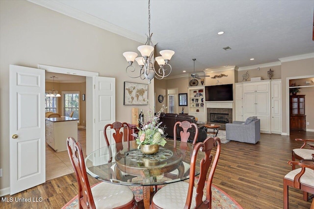 dining space featuring crown molding, a notable chandelier, and hardwood / wood-style flooring