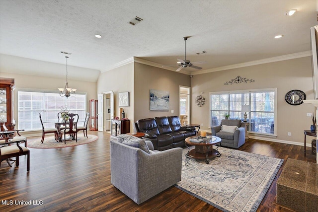 living room with a textured ceiling, plenty of natural light, dark wood-type flooring, and ceiling fan with notable chandelier