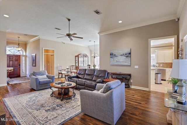 living room with a textured ceiling, ceiling fan with notable chandelier, dark hardwood / wood-style floors, and crown molding