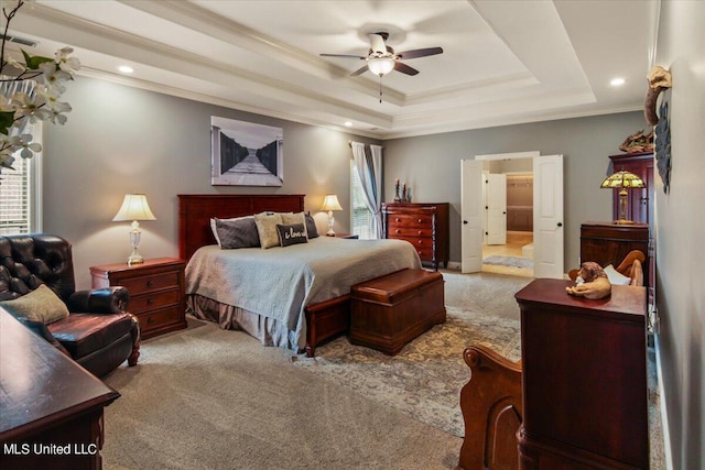 carpeted bedroom featuring crown molding, multiple windows, a tray ceiling, and ceiling fan