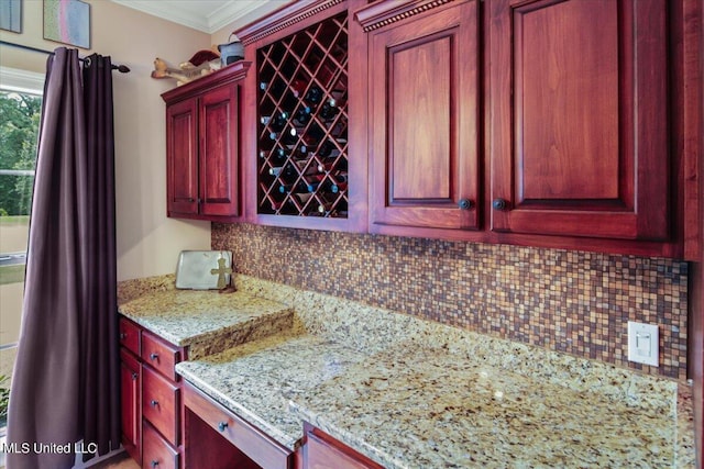 kitchen with crown molding, light stone counters, and backsplash