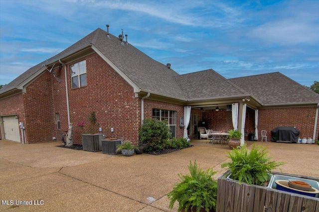 back of house with a patio, cooling unit, and a garage