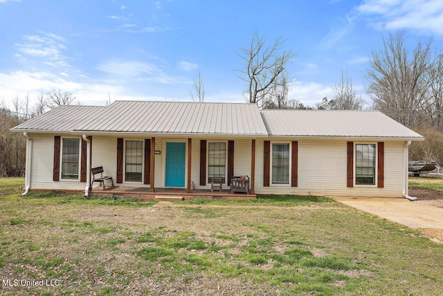 ranch-style home featuring covered porch, metal roof, and a front lawn