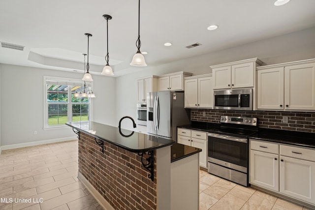 kitchen featuring appliances with stainless steel finishes, dark countertops, visible vents, and backsplash