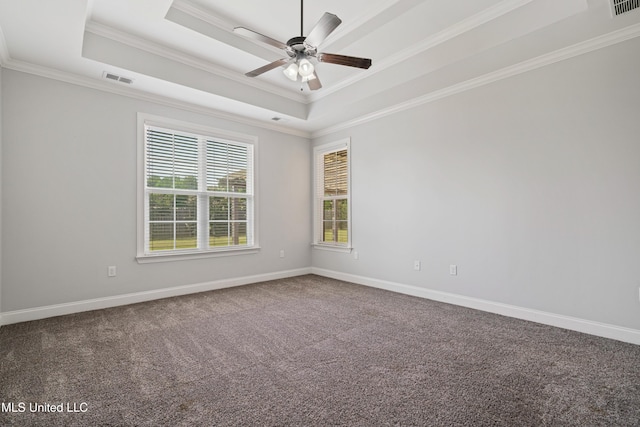 carpeted empty room featuring a tray ceiling, crown molding, and baseboards