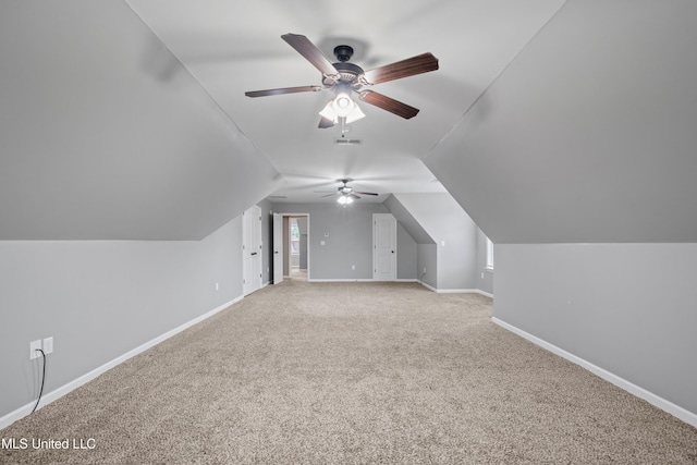 bonus room featuring lofted ceiling, light carpet, visible vents, and baseboards