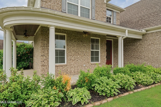 doorway to property with a ceiling fan and brick siding