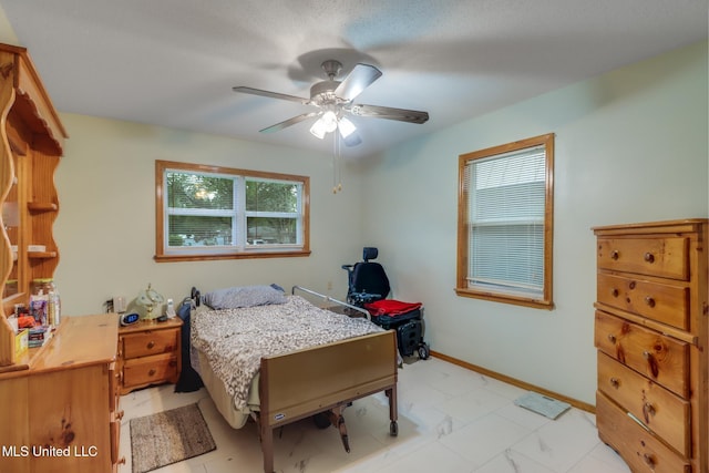 bedroom with baseboards, a ceiling fan, and marble finish floor