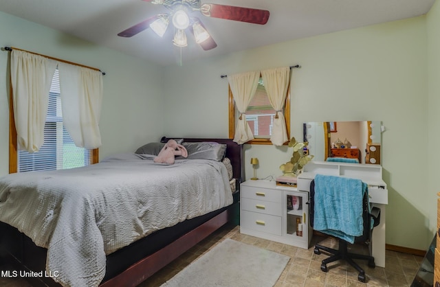 bedroom with baseboards, multiple windows, and a ceiling fan