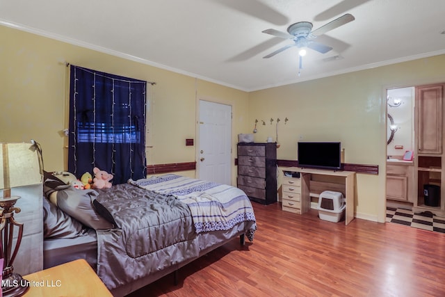 bedroom with visible vents, a ceiling fan, crown molding, ensuite bath, and wood finished floors