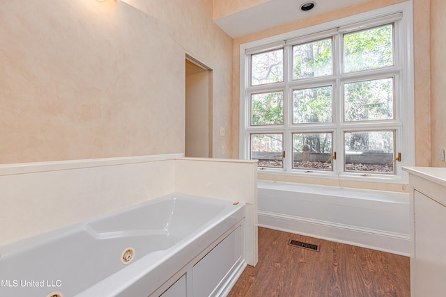 bathroom featuring vanity, a tub, and hardwood / wood-style floors