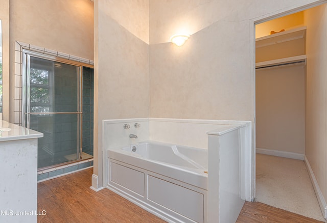 bathroom with plus walk in shower and wood-type flooring