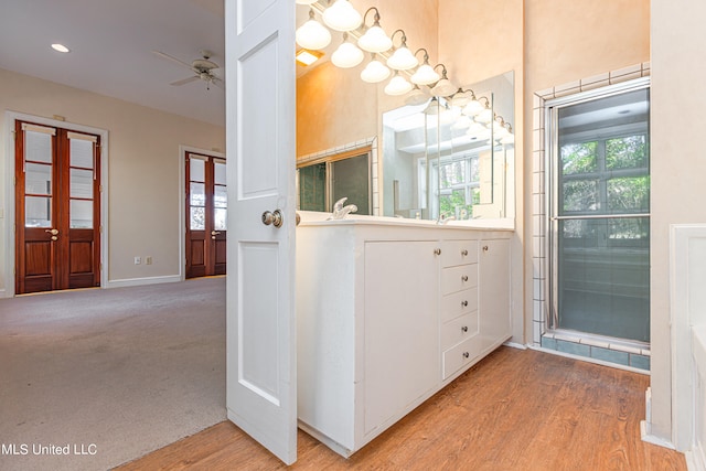 bathroom featuring ceiling fan, hardwood / wood-style flooring, and walk in shower