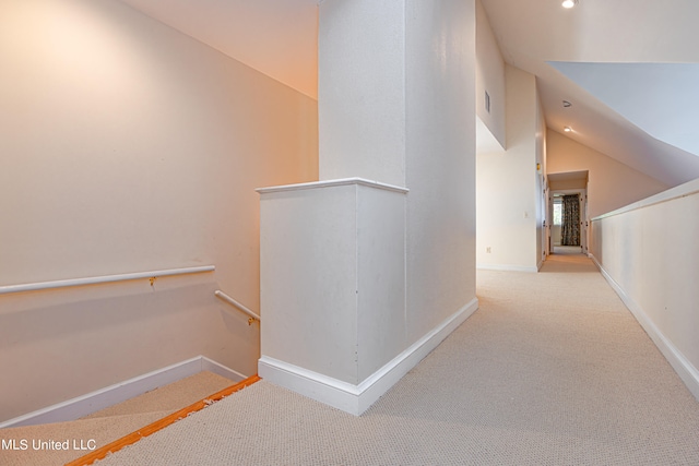 hall with light carpet and vaulted ceiling