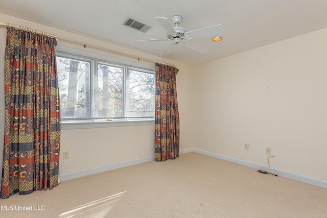 spare room featuring light colored carpet and ceiling fan