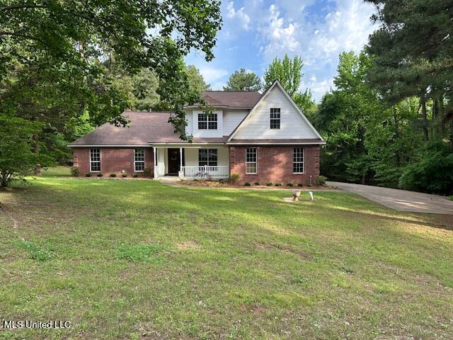 4645 Rebekah Park Dr, Olive Branch, MS 38654 - traditional home featuring a porch, a front yard, and brick siding