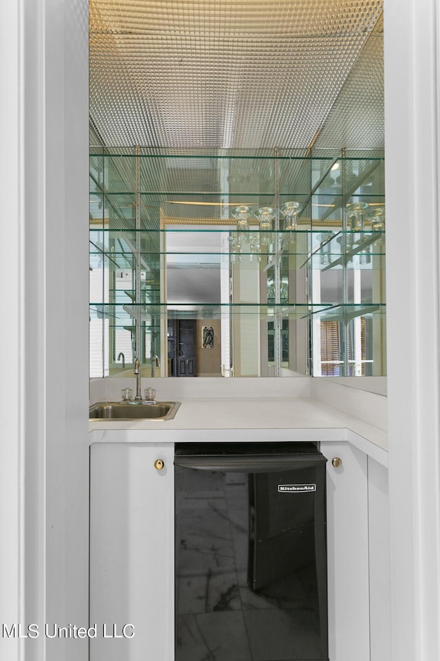 bar featuring beverage cooler, marble finish floor, indoor wet bar, and a sink